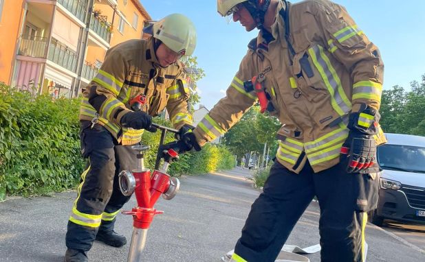 Feuerwehrangehörige setzen und bedienen einen Hydranten